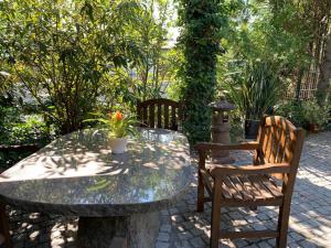 una mesa de piedra con 2 sillas y una mesa con una planta en Hotel Blaufuchs, en Petershagen