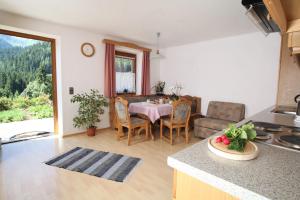 a kitchen and living room with a table and chairs at Bauernhof Strieder in Maria Luggau