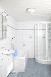 bagno bianco con vasca e doccia di Bauernhof Strieder a Maria Luggau