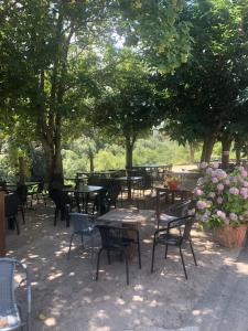 a group of tables and chairs under trees with flowers at Chambre avec balcon à louer in Bains de Guitera
