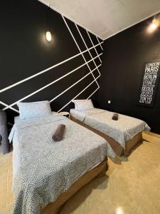 Cette chambre comprend 2 lits et un mur noir. dans l'établissement HIPSTER ROOM at Kuala Berang -Free WiFi & Netflix for 2 Pax, à Kuala Berang