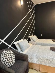 - une chambre avec 2 lits et une chaise dans l'établissement HIPSTER ROOM at Kuala Berang -Free WiFi & Netflix for 2 Pax, à Kuala Berang