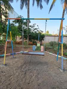 um parque infantil vazio com um baloiço em Doctor's Homestay em Tiruvannamalai