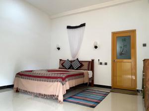 a bedroom with a bed and a window and a door at Villa Sun Rising in Talpe