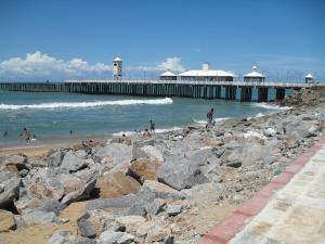 a group of people on the beach near a pier at Suites Vila de Iracema in Fortaleza