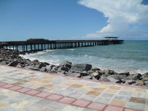 a pier on the beach with the ocean at Suites Vila de Iracema in Fortaleza