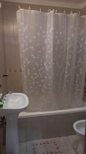 een badkamer met een wastafel en een douchegordijn bij Depto calle 18 - soleado y con balcon in La Plata +19 foto's
