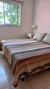 een groot bed in een slaapkamer met een raam bij Depto calle 18 - soleado y con balcon in La Plata