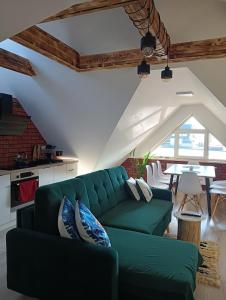 a living room with a green couch and a table at Apartament Nasze Poddasze in Ciche