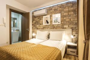 a bedroom with a bed and a brick wall at Sofia Place Hotel by HMG in Sofia