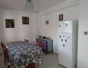 a dining room with a table and a white refrigerator at La Casa del Río, piscina natural a 5 min en coche in Villacarrillo