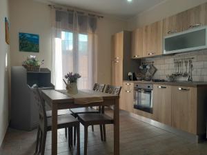 una cucina con tavolo e sedie in legno e una cucina con piano cottura di ANTICO VICOLO a Agrigento