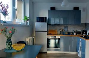 a kitchen with a refrigerator and a table in it at Apartament Przy Parku in Jelenia Góra