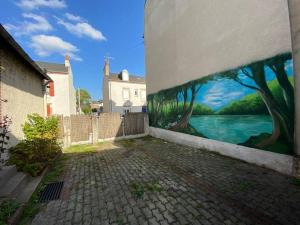 una pintura al lado de un edificio junto a una pared en Maison de ville Orléans dans le Quartier Dunois avec parking privatif, en Orléans