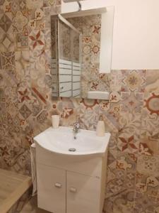 La salle de bains est pourvue d'un lavabo et d'un miroir. dans l'établissement NA ZA ROSA, à Porto Empedocle
