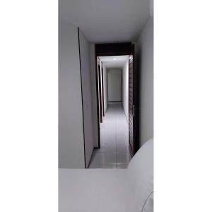 un pasillo con un pasillo que conduce a una habitación en Residencial Barcelona, en João Pessoa