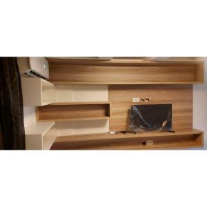 TV en una estantería de madera en una habitación en Residencial Barcelona, en João Pessoa