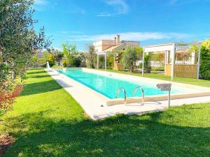 a large swimming pool in a yard with grass at Masseria Vittoria in Acaya