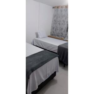 1 dormitorio con 2 camas y ventana en Residencial Barcelona, en João Pessoa