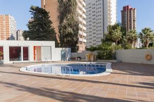 een klein zwembad op een binnenplaats in een stad bij Apartamentos Michel Angelo Benidorm in Benidorm