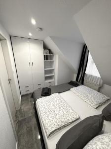 a attic bedroom with two beds and a closet at Downtown Apartments Theatre in Baden-Baden