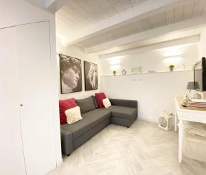 uma sala de estar com um sofá cinzento e almofadas vermelhas em Suite23_Ortigia em Siracusa