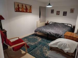 1 dormitorio con 1 cama, 1 silla y 1 mesa en Maison Creusoise dans le village de Fontanières., en Fontanières