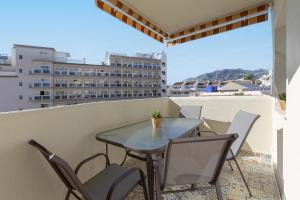 um pátio com uma mesa e cadeiras numa varanda em Apartamento con vistas al mar em Benalmádena