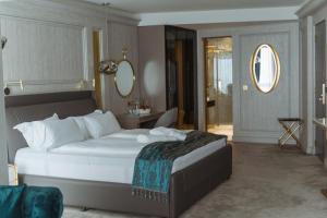 a bedroom with a large white bed and a mirror at Hotel Maris in Ulcinj