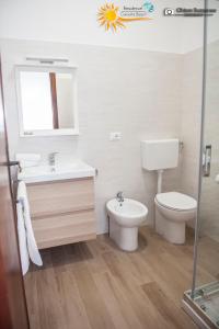 ein Badezimmer mit einem Waschbecken, einem WC und einem Spiegel in der Unterkunft Cannotta Beach - Salina in Terme Vigliatore