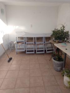 una habitación con una mesa y una mesa y algunas plantas en Casa Alvear en Marcos Juárez