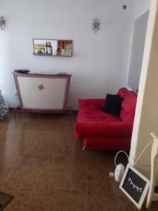 sala de estar con sofá rojo y mesa en Casa Alvear en Marcos Juárez