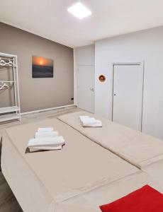 Cette chambre blanche comprend 2 oreillers blancs et un tapis rouge. dans l'établissement SAINT GEORGE'S HOUSE 3 Bari, à Bari