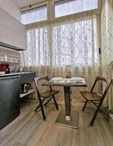 une cuisine avec une table et des chaises devant une fenêtre dans l'établissement SAINT GEORGE'S HOUSE 3 Bari, à Bari
