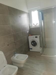 een badkamer met een toilet en een wasmachine bij APPARTAMENTI SOLE-LUNA in Francavilla al Mare