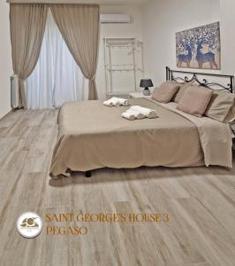 - une chambre avec un grand lit et du parquet dans l'établissement SAINT GEORGE'S HOUSE 3 Bari, à Bari