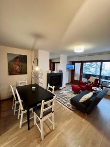 un soggiorno con tavolo, sedie e divano di Renovated Apartment 5 min to Crans Montana Center a Crans-Montana