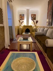 sala de estar con sofá y mesa en Riad Dar Lilas, en Marrakech