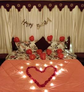 a bed with a heart with lights and a happy birthday sign at Exotic Stay - a unique experience in Pune
