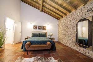 ein Schlafzimmer mit einem Bett und einer Steinmauer in der Unterkunft Casa da Serra in Arrimal