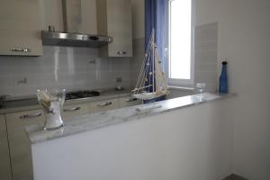 eine Küchentheke mit einer Vase mit einem Boot darauf in der Unterkunft Cannotta Beach - Panarea in Terme Vigliatore