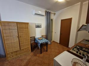 a small kitchen with a table and a room with a table at Monolocali in centro paese in Lampedusa