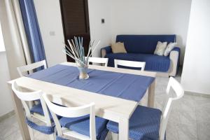 einen Tisch und Stühle mit einem blauen Tisch und einer Couch in der Unterkunft Cannotta Beach - Panarea in Terme Vigliatore