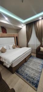 1 dormitorio con 1 cama grande y 1 sofá en Admire Apart Hotel - 2, en Aḩad al Masāriḩah