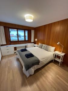 a bedroom with a large bed and wooden walls at Renovated Apartment 5 min to Crans Montana Center in Crans-Montana