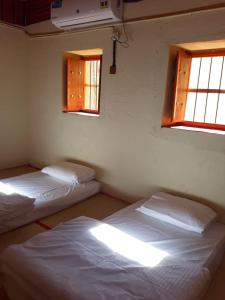 Een bed of bedden in een kamer bij Mahalli Balad Sayt Heritage Inn