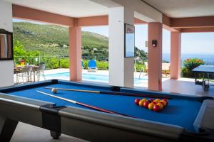 una mesa de billar en una habitación con piscina en Villa Natasha, en Ratzaklíon