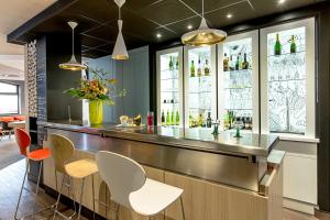 a bar in a restaurant with chairs and bottles at ibis Colmar Centre in Colmar