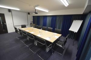 a conference room with a long table and chairs at Lancaster Hotel in Uxbridge