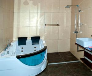 a bathroom with a tub and a sink and a shower at Lake Safari Lodge in Siavonga